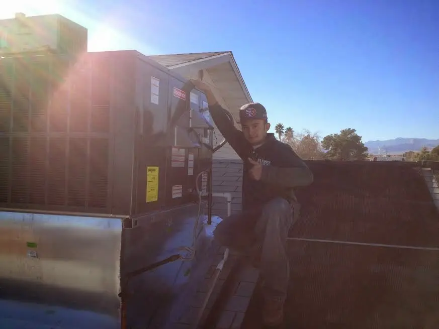 HVAC technician performing AC Tune-Up on a rooftop unit in Homestead Meadows North
